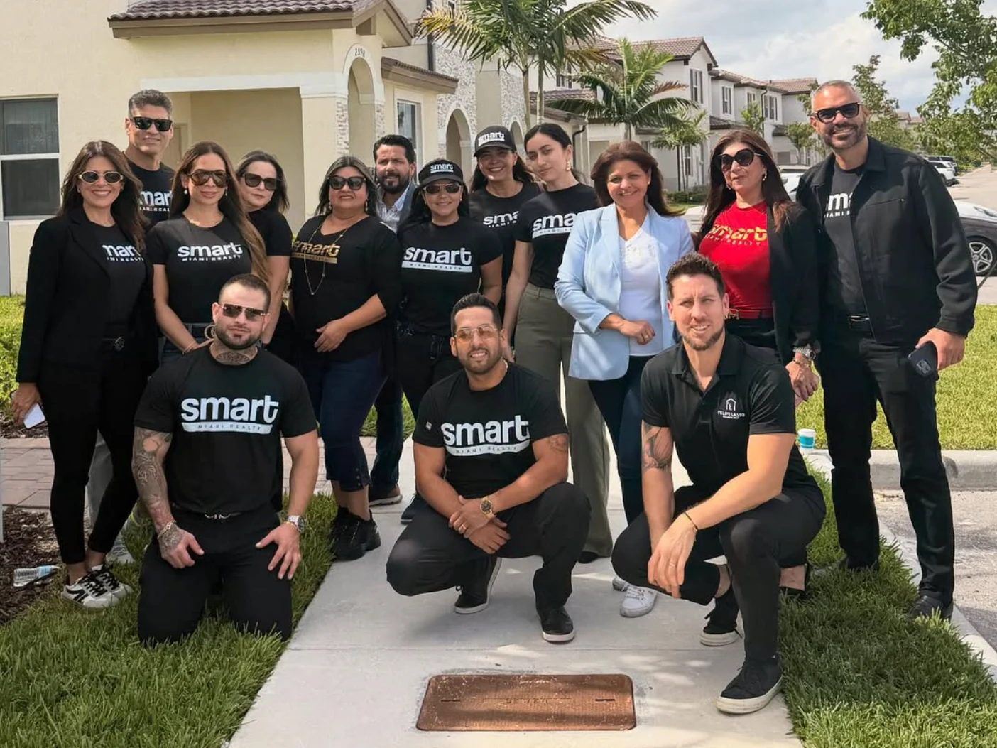 Smart Miami Realty real estate agents together outdoors, with many wearing Smart-branded shirts.