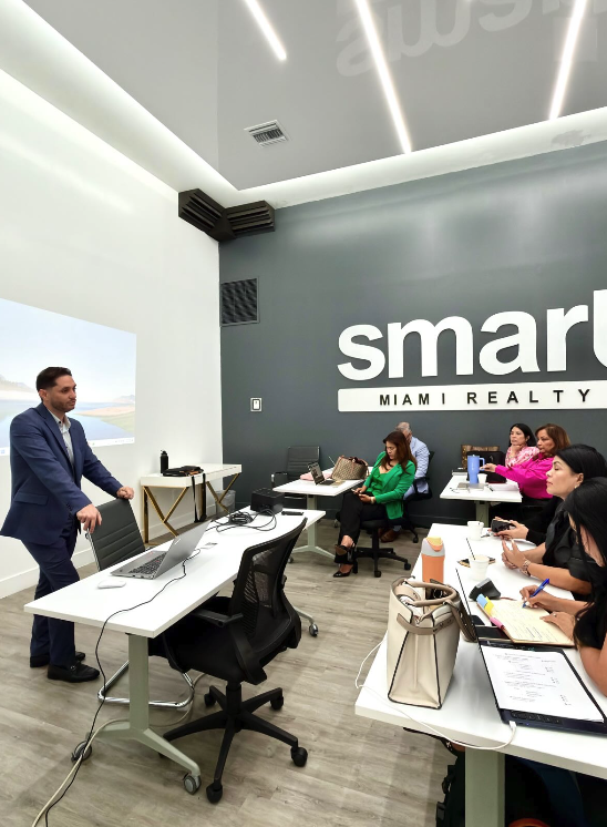 Smart Miami Realty agents attending a weekly training session with a presenter at the office.